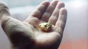 Nahaufnahme von einem Stück Gold in einer Hand
