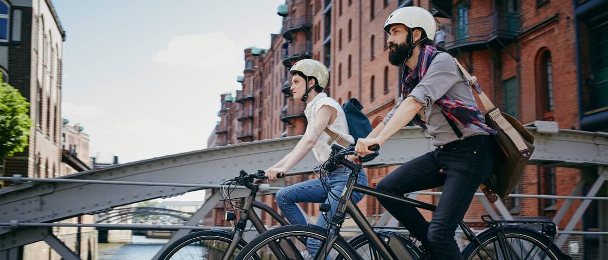 Mann und Frau in der Stadt unterwegs mit dem Fahrrad