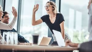 Frau hält einen Vortrag vor Kunden oder Kollegen an einem Besprechungstisch