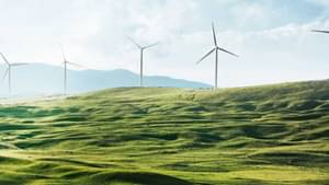 Wind turbines against the background of a field and the text "Acting responsibly, growing sustainably"