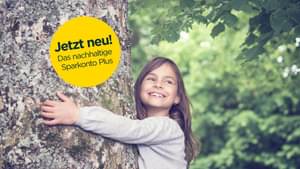 Ein junges Mädchen umarmt lachend einen Baum. Jetzt neu! Das nachhaltige Sparkonto Plus
