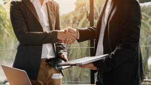 Two men can be seen shaking hands