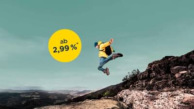 Ein Mann mit gelber Jacke und Rucksack springt von einem Felsabsatz herunter und streckt beide Arme zur Seite aus. Ratenkredit ab 2,99% p.a.*